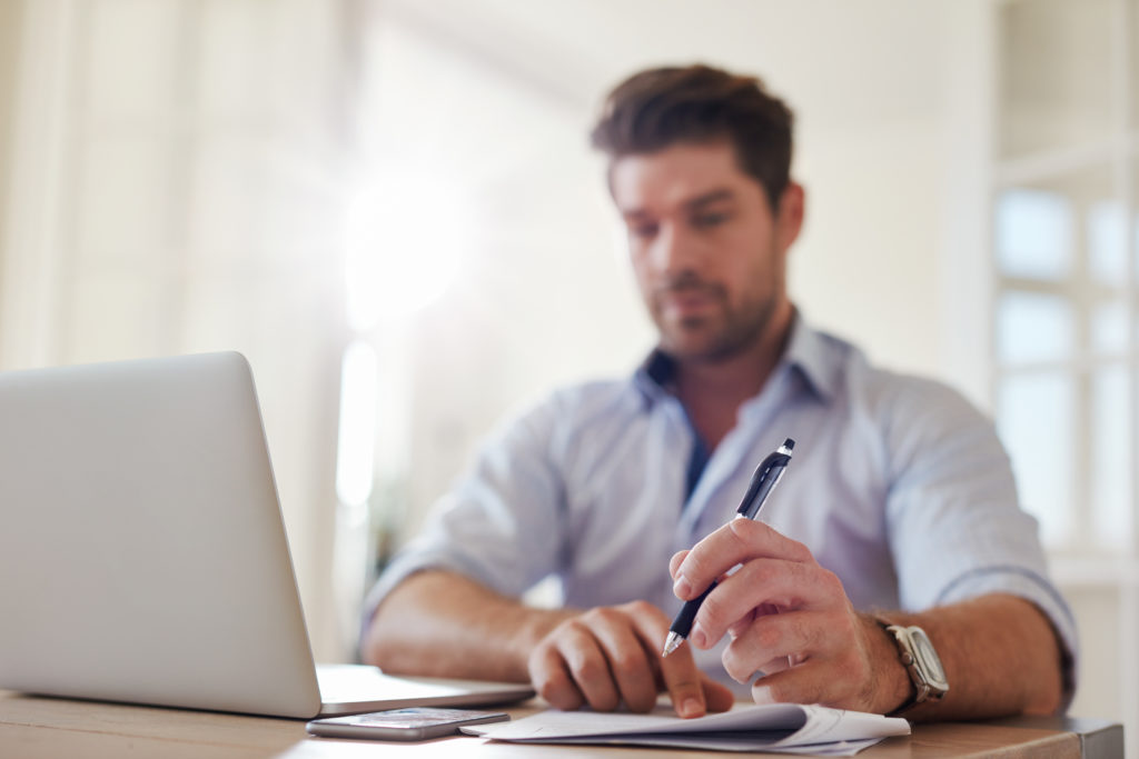 Empresário no escritório doméstico tomando notas
