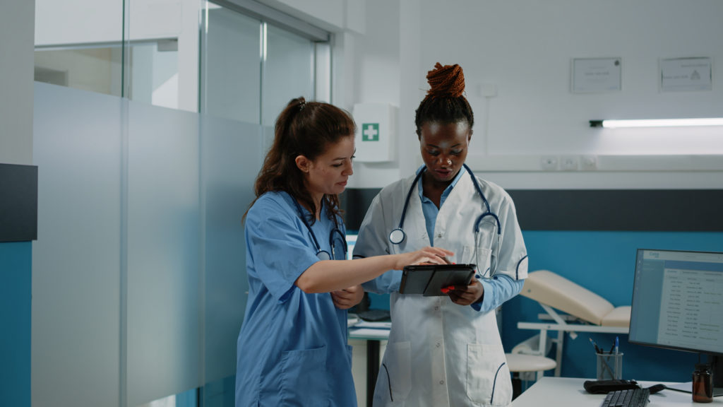 Médico e enfermeiro trabalhando com tablet para sistema de saúde