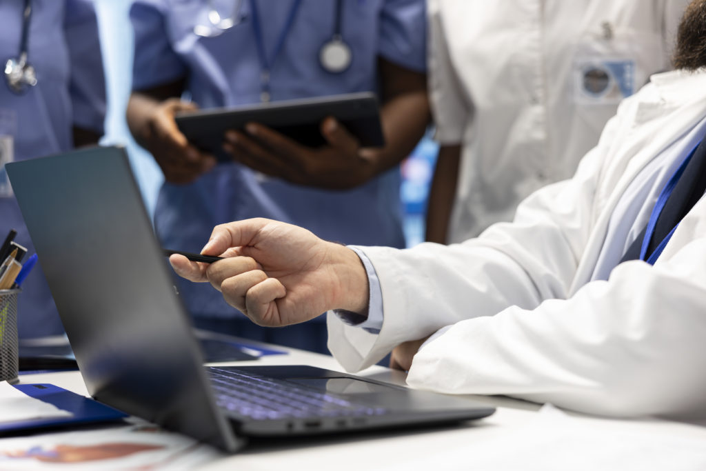 Médico licenciado examinando resultados de testes e registros de saúde em reunião de gabinete
