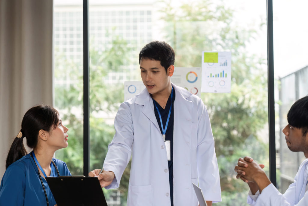 Médico liderando uma reunião sobre cuidados ao paciente e percepções médicas