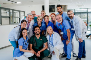 Retrato de médicos, enfermeiros e outros profissionais de saúde felizes no hospital.