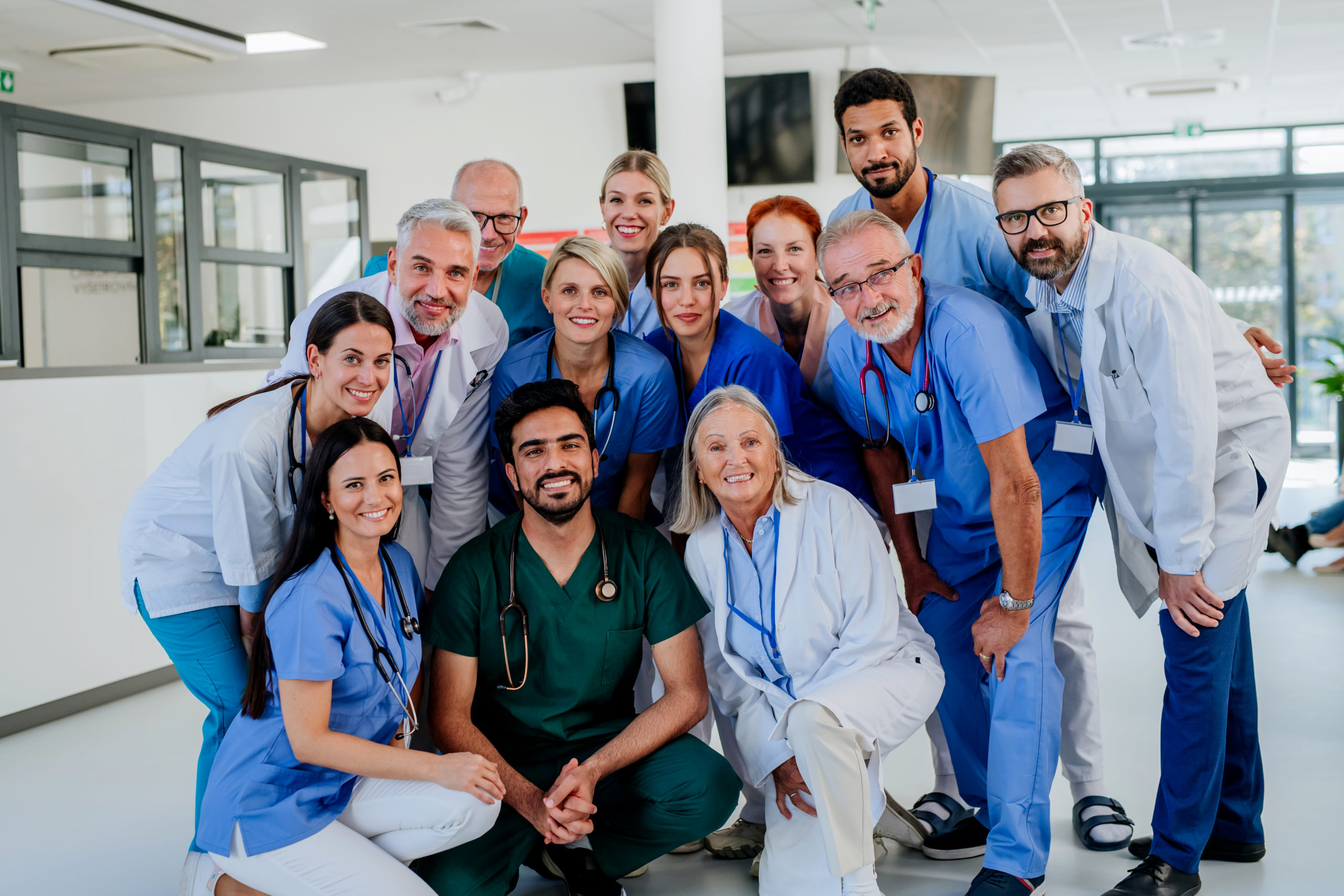 Retrato de médicos, enfermeiros e outros profissionais de saúde felizes no hospital.