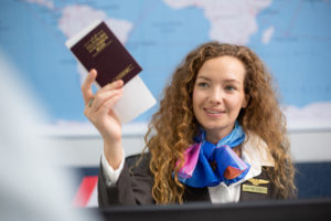 Policial entrega passaporte e cartão de embarque a passageiro